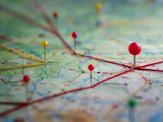 A close-up of a paper map with some push pins marking some relevant spots.